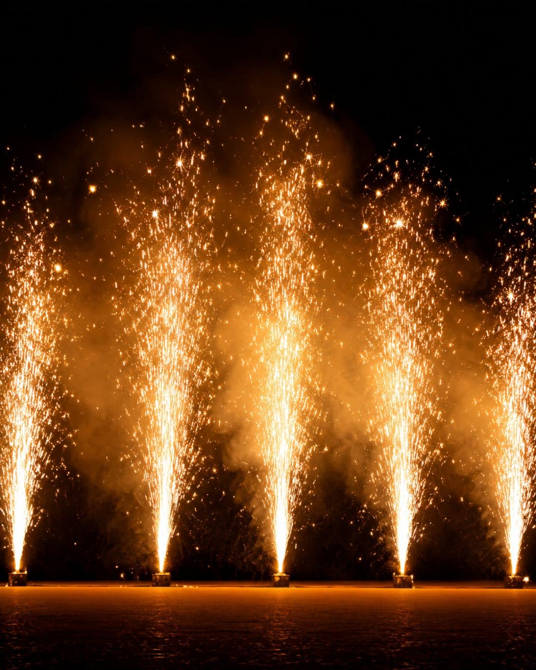 Goldene Bodenfontänen über Wasser